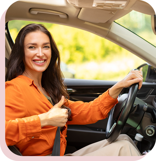 A woman in an orange shirt is driving