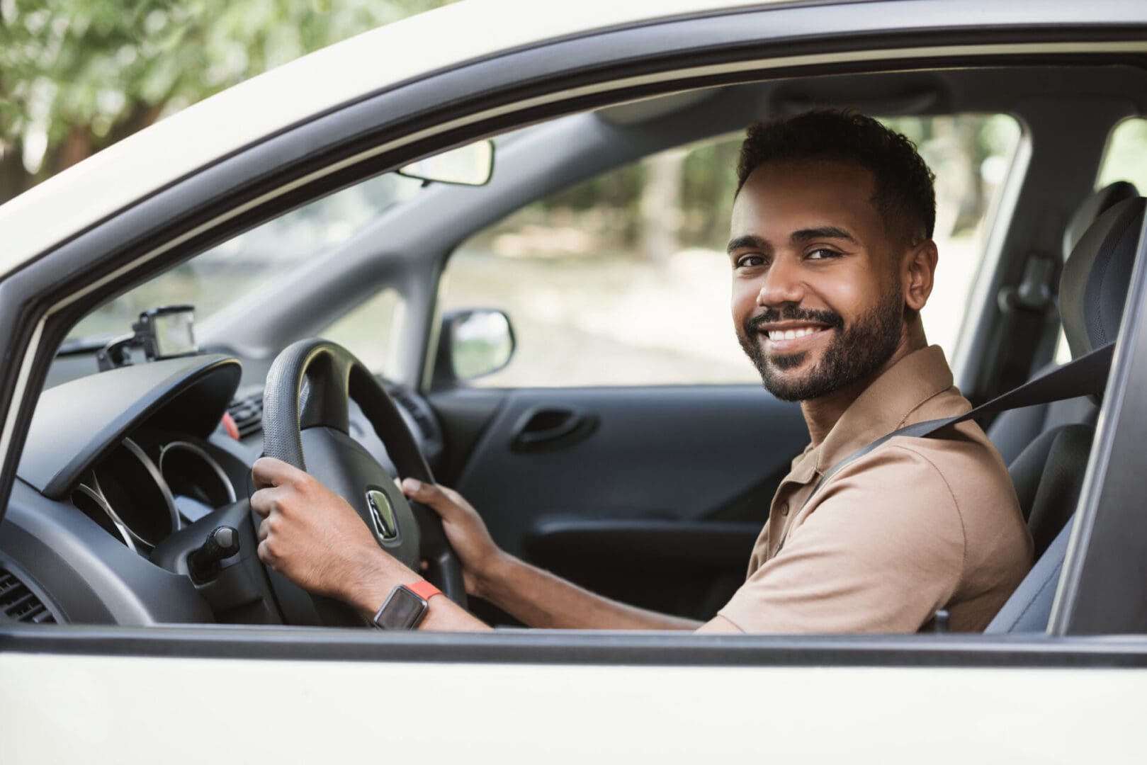 A man sitting in the drivers seat of his car.